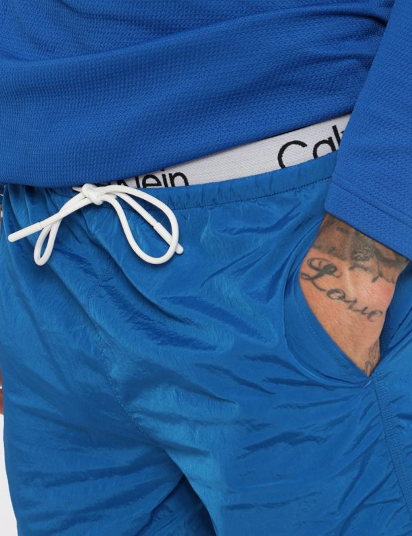 Bermuda Calvin Klein Blu - Bermuda in total blu elettrico. Presenti tasche a taglio trasversale più tasca a taglio con chius