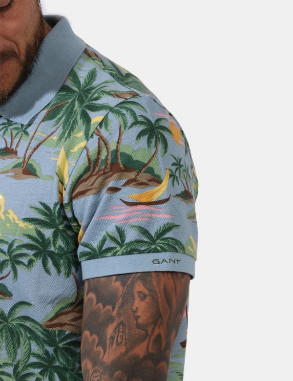 Polo Gant Fantasia - Polo su base azzurro pastello con stampa allover palme e tramonti in tinta coordinata. Presente collett