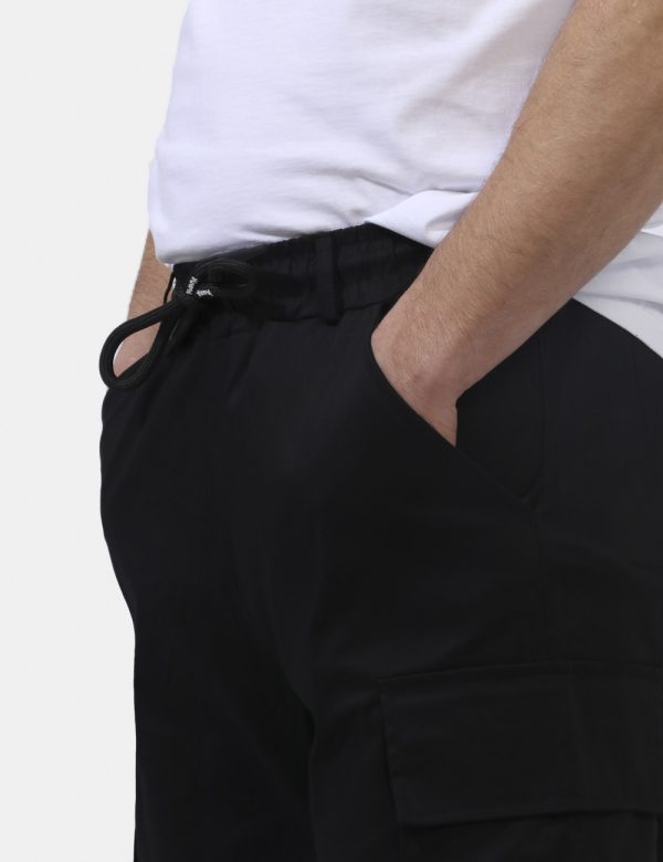 Pantaloni Disclaimer Nero - Pantaloni in total nero con tasche a taglio trasversale più doppie tasche a toppa laterali. La v
