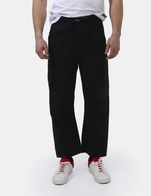 Pantaloni Disclaimer Nero - Pantaloni in total nero con tasche a taglio trasversale più doppie tasche a toppa laterali. La v