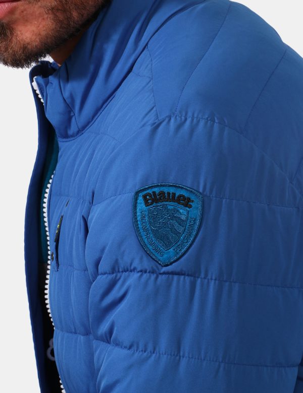 Piumino Blauer Blu - Piumino in total blu ceruleo. Presenti tasche a taglio trasversale con chiusura a zip più tasche intern