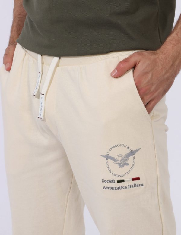 Pantaloni Aeronautica Italiana Bianco - Pantaloni simil tuta in total bianco latte con polsino sul girocaviglia. Presenti ta