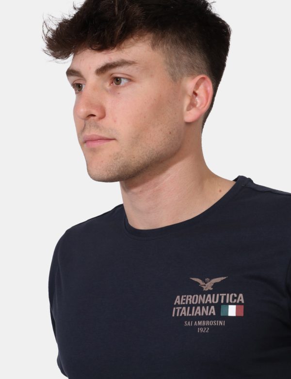 T-shirt Aeronautica Italiana Blu - T-shirt su sfondo blu navy con stampa logo brand ad altezza cuore. La vestibilità è morbi