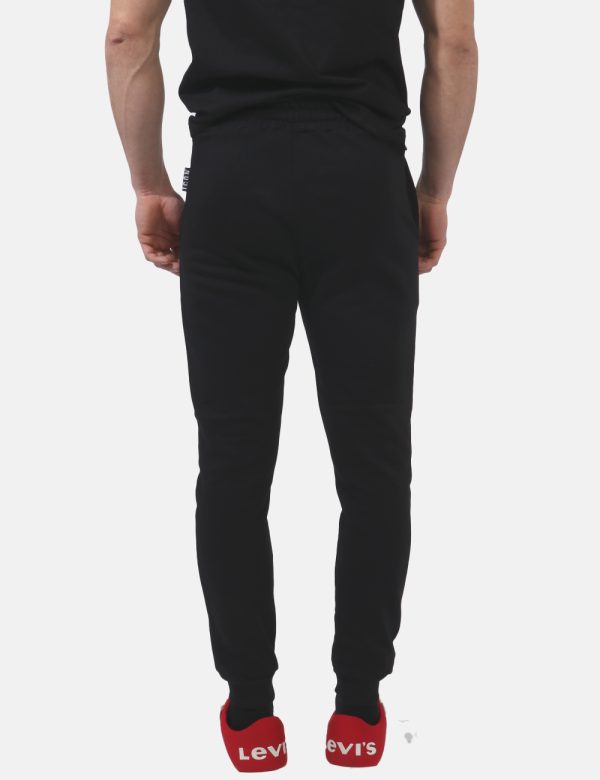 Pantaloni Icon Nero - Pantaloni felpati in total nero con logo brand in giallo fluo e tasche a taglio trasversale. Presenti