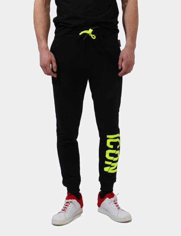 Pantaloni Icon Nero - Pantaloni felpati in total nero con logo brand in giallo fluo e tasche a taglio trasversale. Presenti