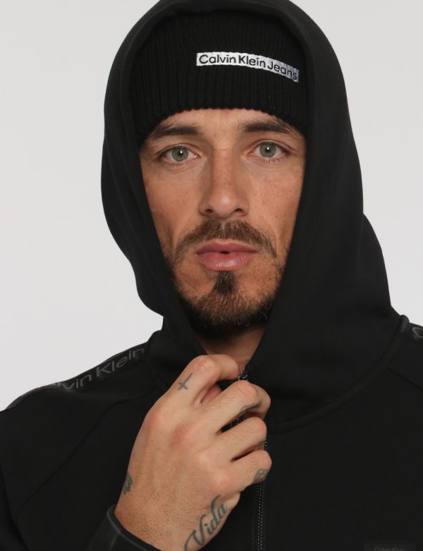 Felpa Calvin Klein Nero - Felpa a collo alto con cappuccio in total nero. Presenti tasche a taglio trasversale. La vestibil