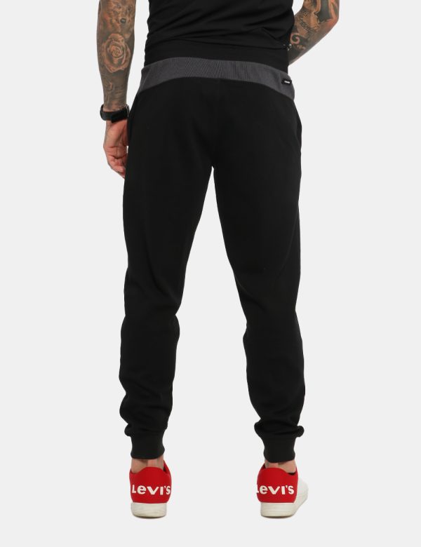 Pantaloni Calvin Klein Nero - Pantaloni felpati in total nero. Presenti tasche a taglio trasversale e logo brand ricamato su
