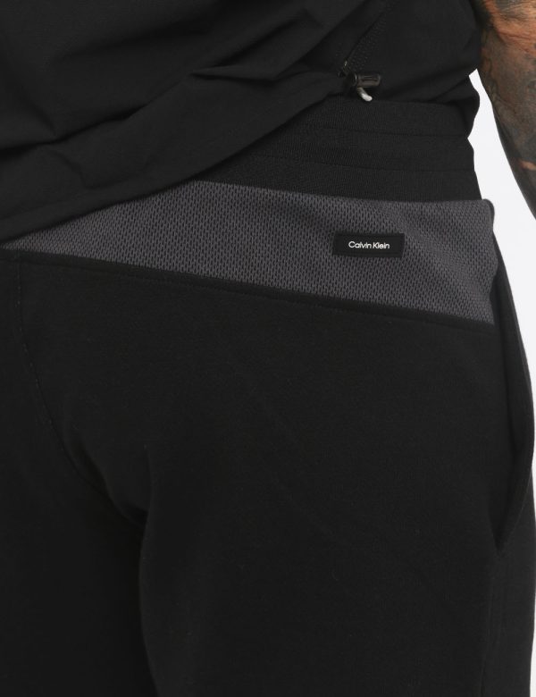 Pantaloni Calvin Klein Nero - Pantaloni felpati in total nero. Presenti tasche a taglio trasversale e logo brand ricamato su