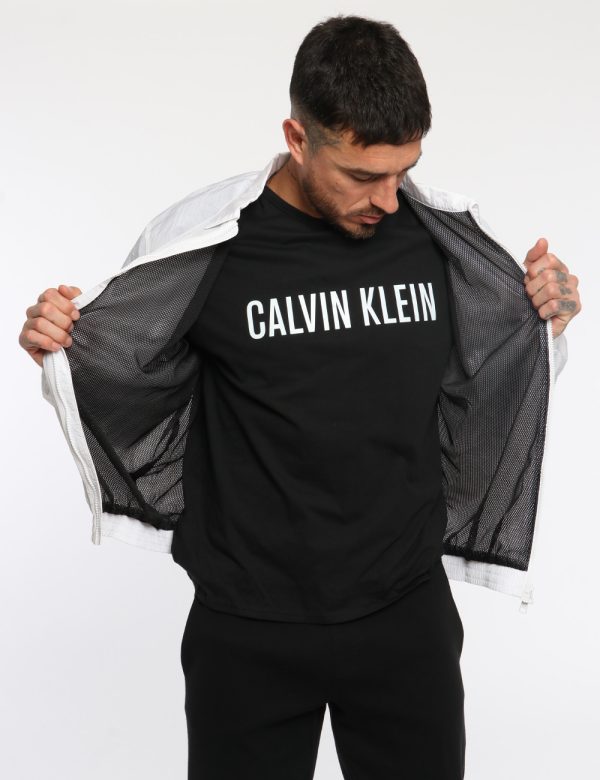Giacca Calvin Klein Bianco - Giacca simil kway leggero in total bianco con interno traforato nero. Presenti tasche a taglio