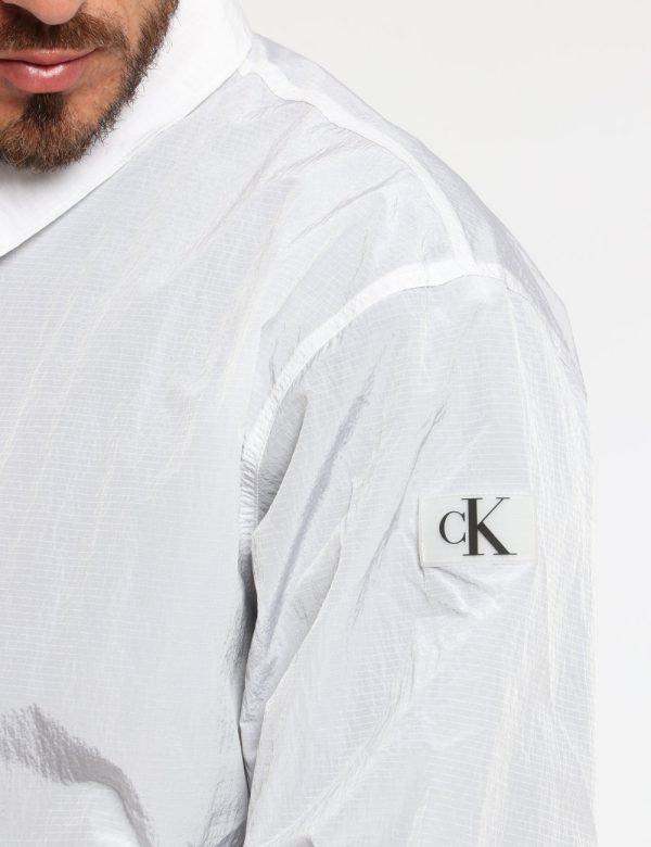 Giacca Calvin Klein Bianco - Giacca simil kway leggero in total bianco con interno traforato nero. Presenti tasche a taglio