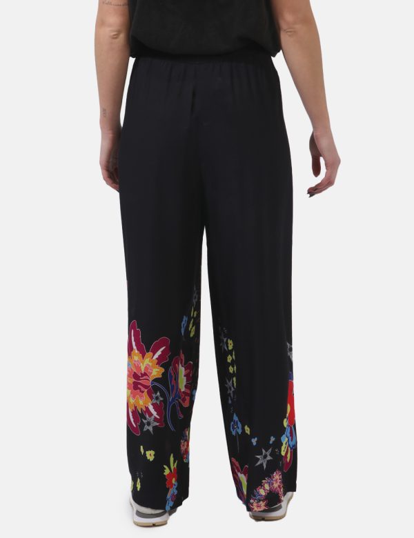 Pantaloni Desigual Nero - Pantaloni larghi in viscosa su base nera con stampa floreale tendente al fucsia e all'arancione. L