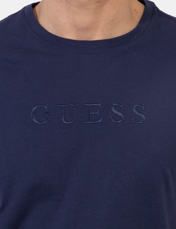 T-shirt Guess Blu - T-shirt in total blu navy con logo brand ricamato in tono su tono. La vestibilità è morbida e regolare.