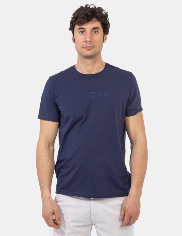T-shirt Guess Blu - T-shirt in total blu navy con logo brand ricamato in tono su tono. La vestibilità è morbida e regolare.