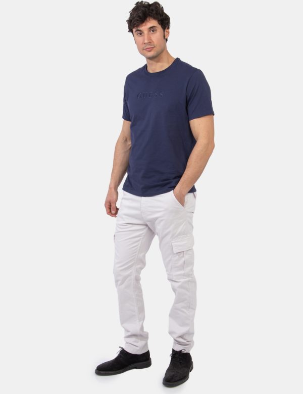 Pantaloni Guess Bianco - Pantaloni in total bianco sporco. Presenti tasche a taglio trasversale e tasche a toppa laterali co