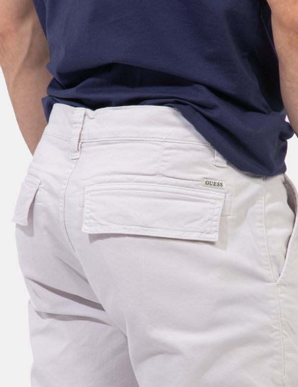 Pantaloni Guess Bianco - Pantaloni in total bianco sporco. Presenti tasche a taglio trasversale e tasche a toppa laterali co