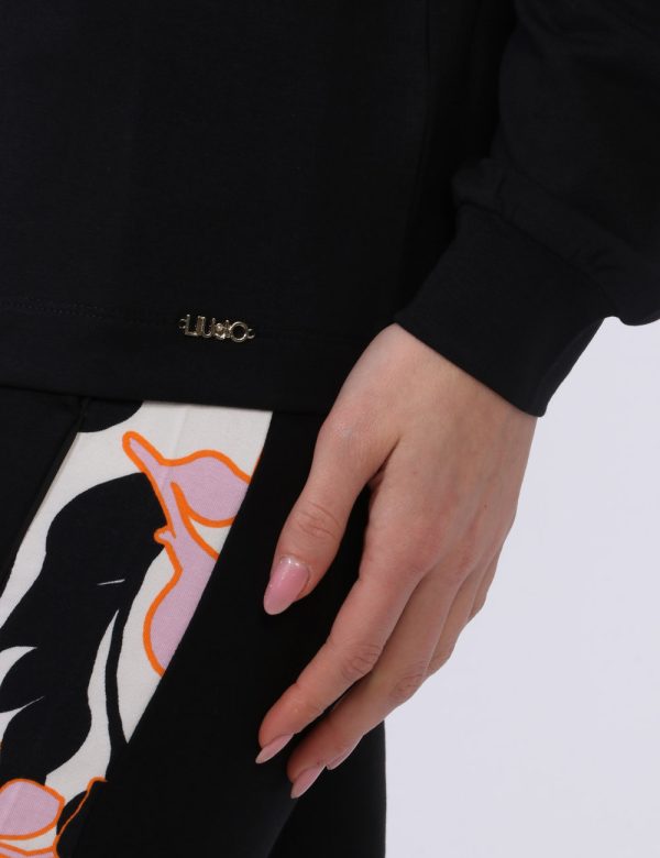 Felpa Liu-Jo Nero - Felpa con girocollo classico su base nera con banda floreale in tinta tendente al rosa. La vestibilità è