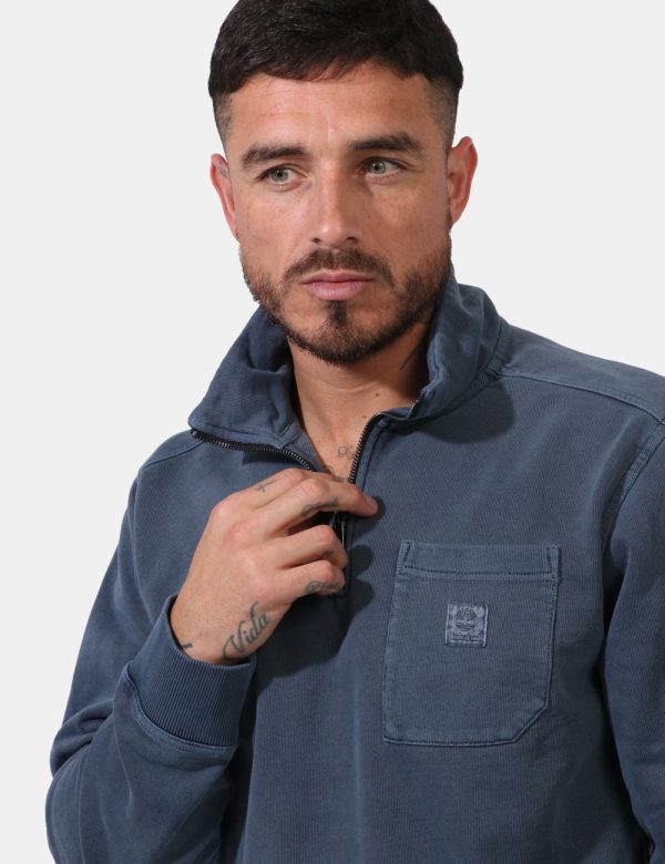 Felpa Timberland Blu - Felpa in total blu slavato con collo alto. Presente taschino a taglio trasversale. La vestibilità è m