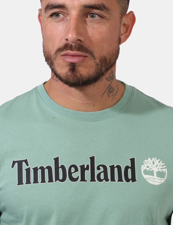 T-shirt Timberland Verde - T-shirt su sfondo verde chiaro con ampia stampa logo brand in tinta coordinata. La vestibilità è