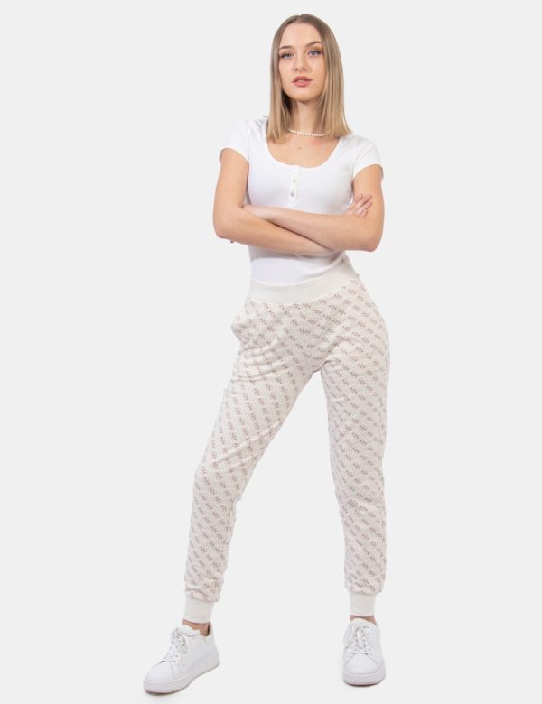 Pantaloni Guess Beige - Pantaloni felpati su base beige con stampa allover logo brand in tinta marrone. Presenti tasche a ta