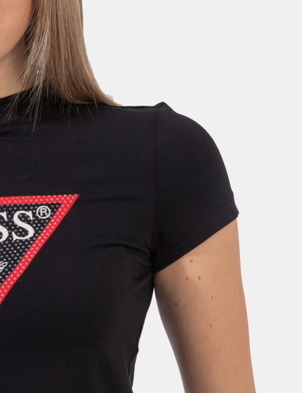 T-shirt Guess Nero - T-shirt corta su base nera con logo brand al centro in bianco e nero e glitter coordinati. La vestibili
