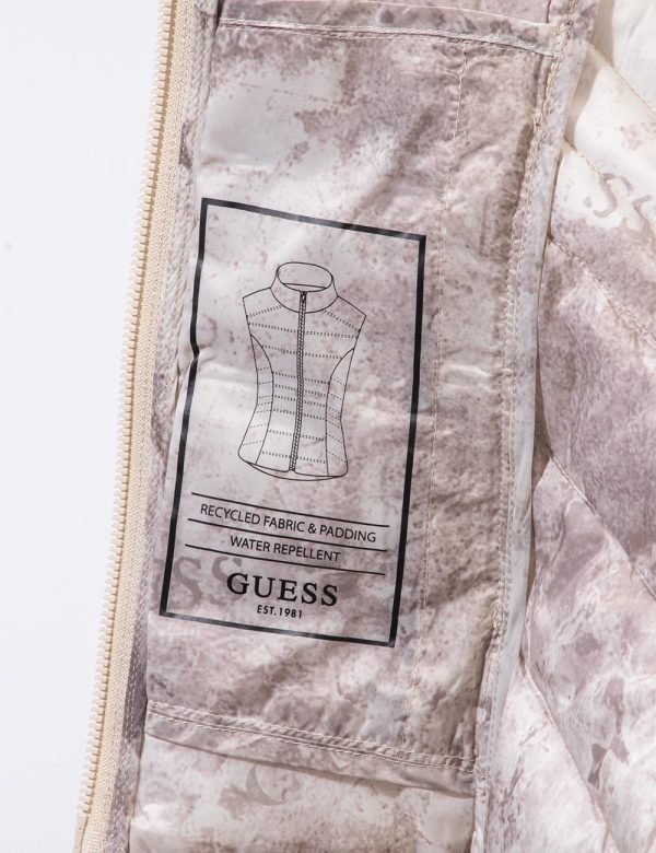 Gilet piumino Guess Beige - Piumino smanicato in total beige. Presenti tasche a taglio trasversale con chiusura a zip. La ve