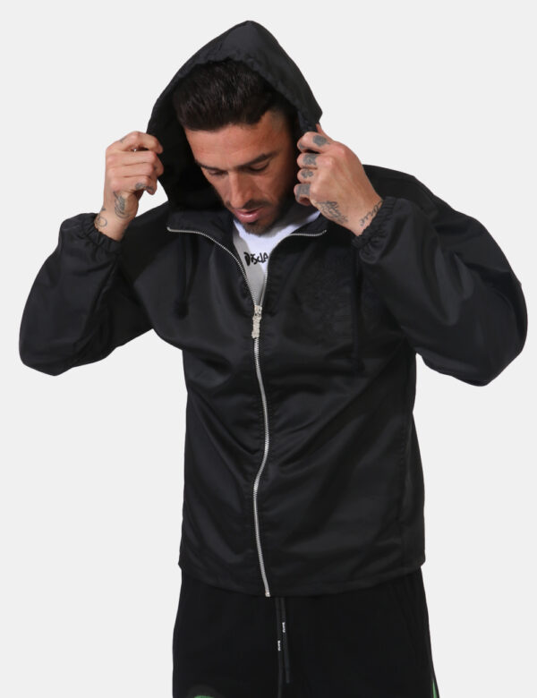 Giacca Disclaimer Nero - Giacca con cappuccio in total nero simil acetato. Presenti tasche a taglio trasversale. La vestibil