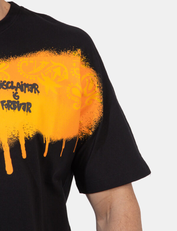 T-shirt Disclaimer Nero - T-shirt su sfondo nero con stampa logo brand nero e arancione sul fronte. La vestibilità è morbida