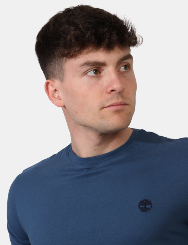 T-shirt Timberland Blu - T-shirt in total azzurro grigiastro con patch logo brand nero ad altezza cuore. La vestibilità è mo