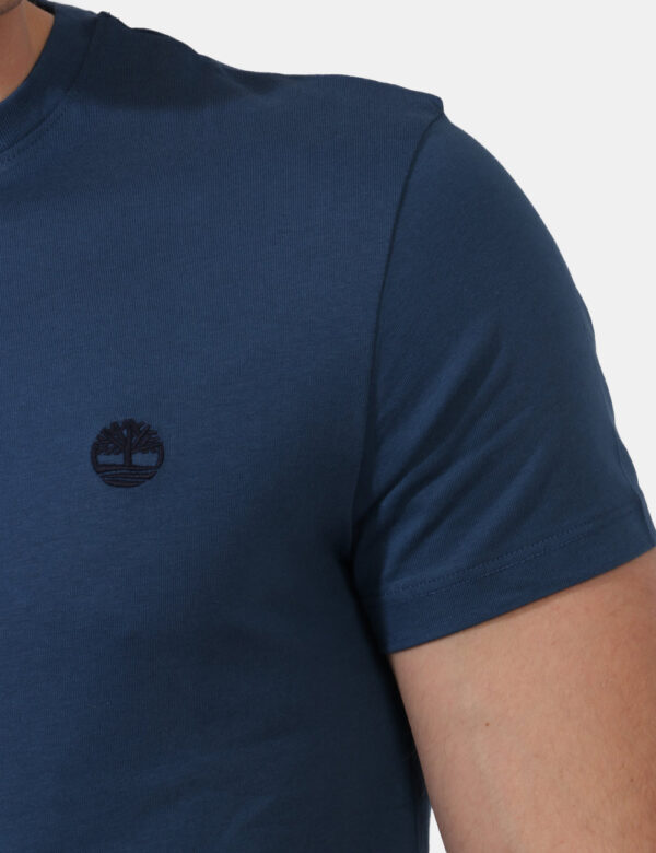 T-shirt Timberland Blu - T-shirt in total azzurro grigiastro con patch logo brand nero ad altezza cuore. La vestibilità è mo