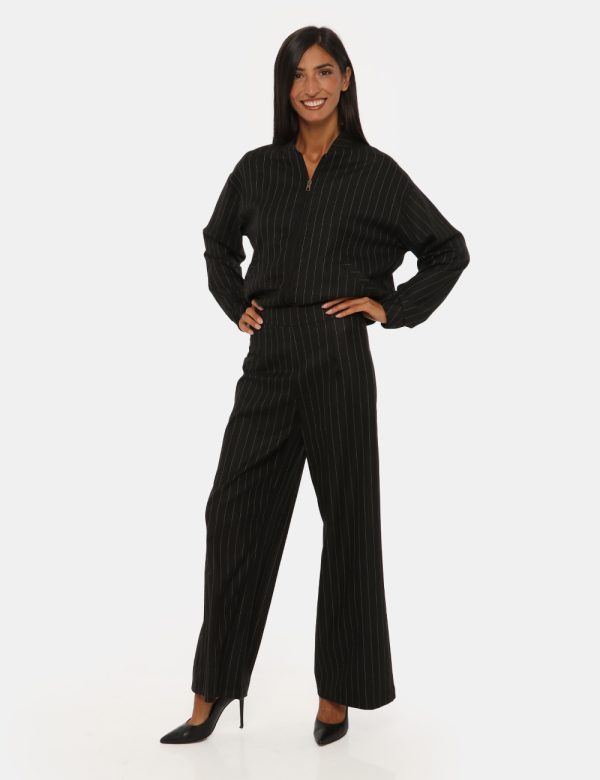 Pantalone Vougue nero gessato - COMPOSIZIONE E VESTIBILITÀ:63% poliestere 34% viscosa 3% elastaneLa modella è alta 176 cm e