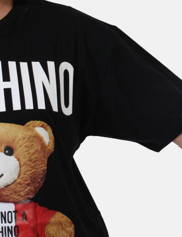 T-shirt Moschino Nero - T-shirt lunga su base nera con simpatica stampa 'Moschino Toy' in bianco e marrone. La vestibilità è