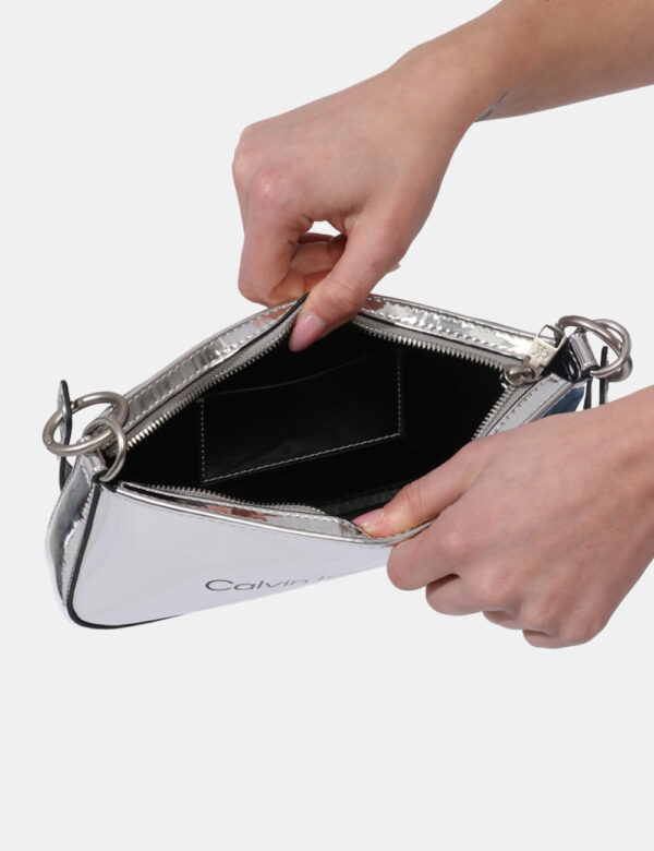 Borsa Calvin Klein Argento - Borsa a mano modello pochette in total argento lucido. L'interno è composto da unico scompartim