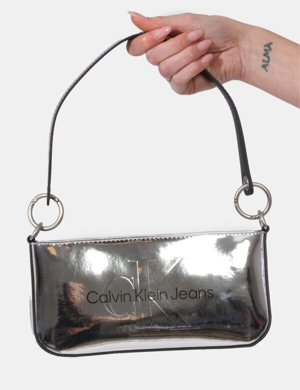 Borsa Calvin Klein Argento - Borsa a mano modello pochette in total argento lucido. L'interno è composto da unico scompartim