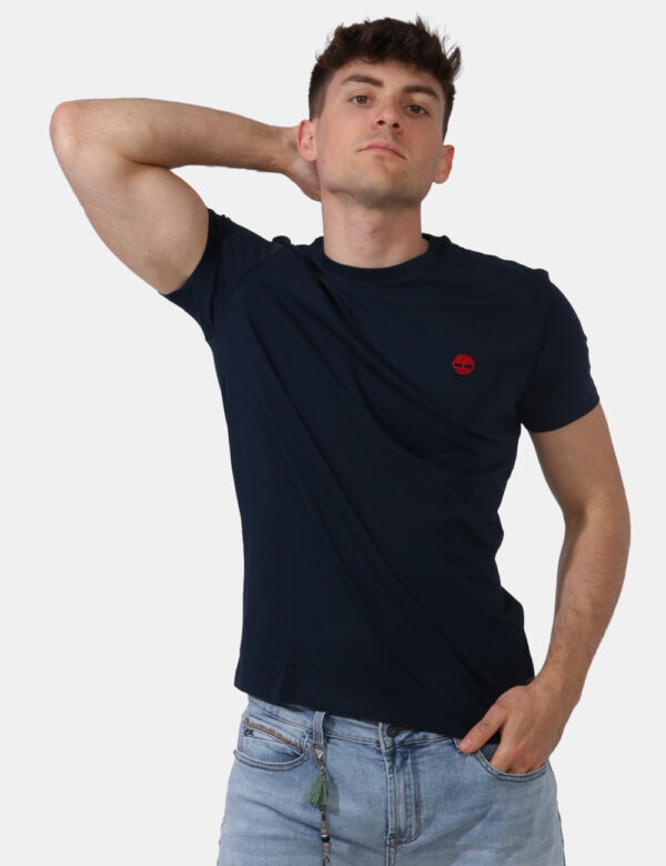 T-shirt Timberland Blu - T-shirt in total blu navy con patch logo brand rosso ad altezza cuore. La vestibilità è morbida e r