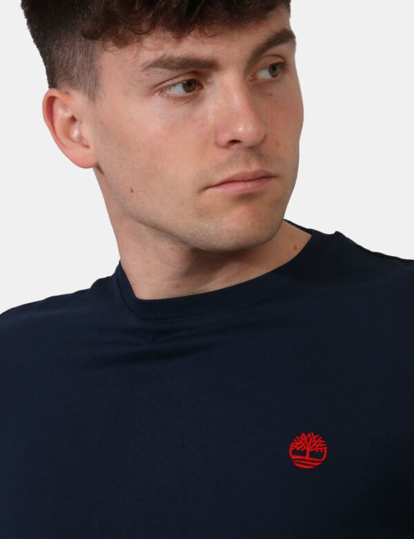T-shirt Timberland Blu - T-shirt in total blu navy con patch logo brand rosso ad altezza cuore. La vestibilità è morbida e r