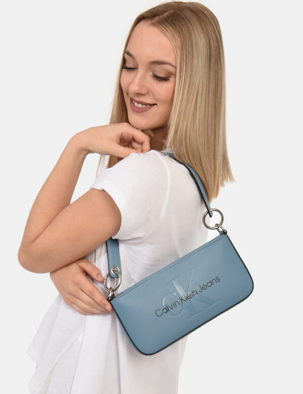 Borsa Calvin Klein Azzurro - Borsa a mano modello pochette in total azurro con logo brand. L'interno è composto da unico sco
