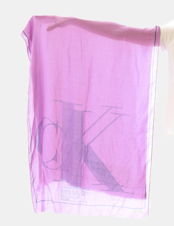 Foulard Calvin Klein Lilla - Ampio foulard su sfondo lilla con dettagli e logo brand in tinta coordinata. Il capo è pratico