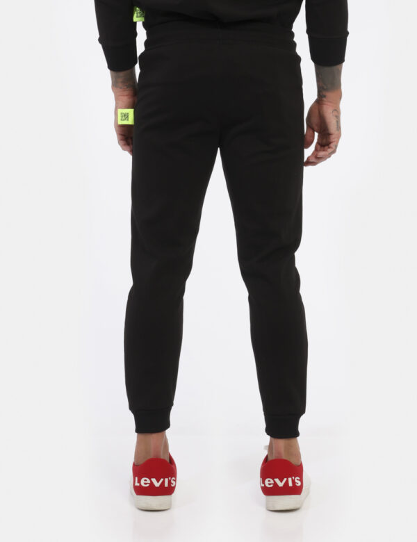 Pantaloni Icon Nero - Pantaloni simil tuta in total nero con logo brand nero lucido. Presente tascone unico con taglio trasv