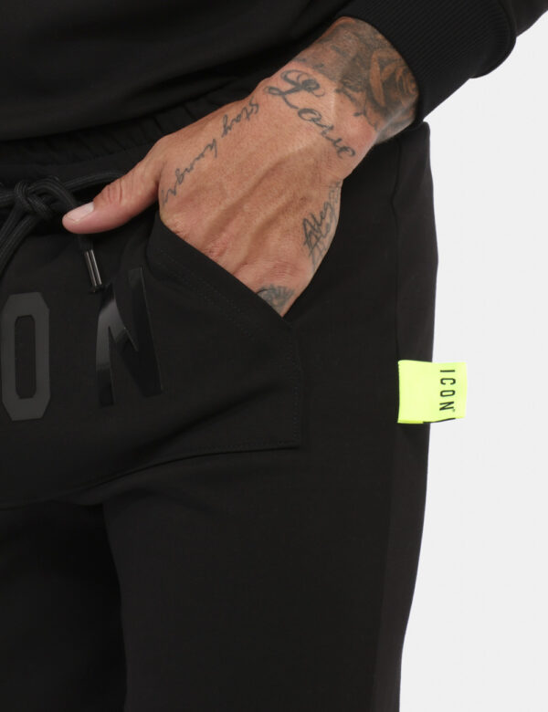 Pantaloni Icon Nero - Pantaloni simil tuta in total nero con logo brand nero lucido. Presente tascone unico con taglio trasv