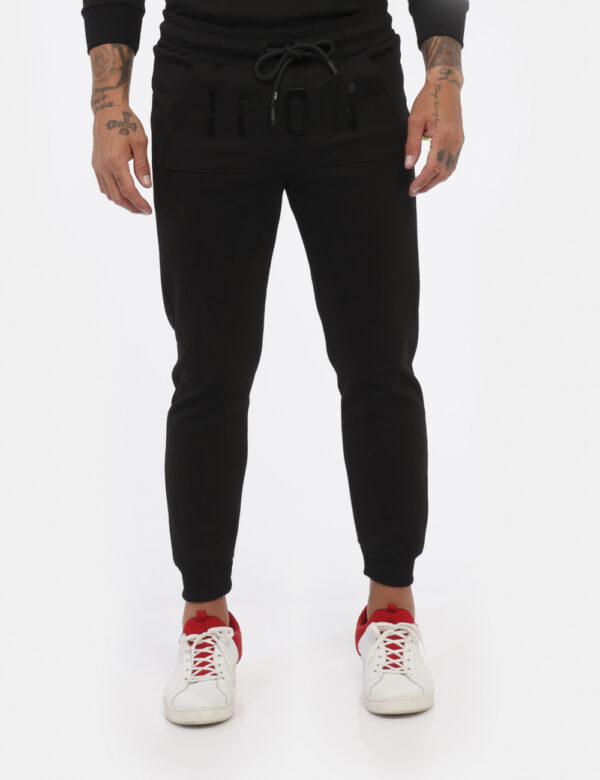 Pantaloni Icon Nero - Pantaloni simil tuta in total nero con logo brand nero lucido. Presente tascone unico con taglio trasv