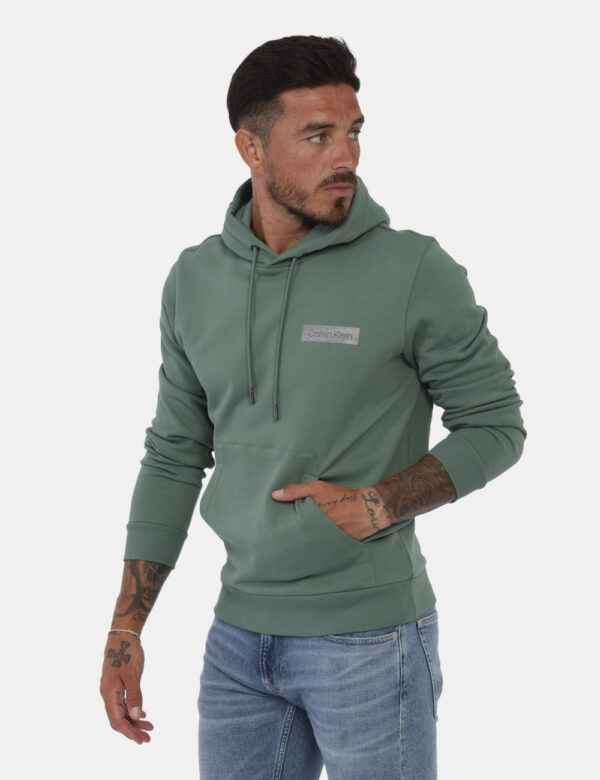 Felpa Calvin Klein Verde - Felpa con cappuccio in total verde con logo brand argentato. Presente tascone a toppa. La vestibi
