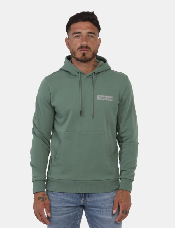 Felpa Calvin Klein Verde - Felpa con cappuccio in total verde con logo brand argentato. Presente tascone a toppa. La vestibi