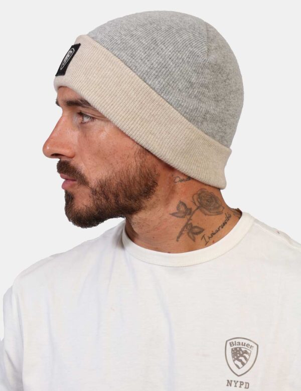 Cappello Blauer Grigio - Cappello modello berretto bicolore grigio e beige con risvoltino e patch nero logo brand. La vestib