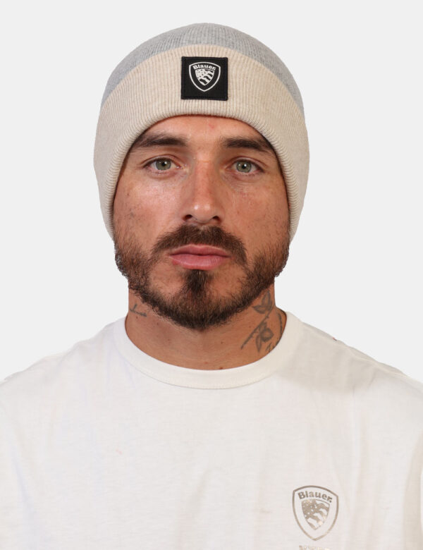Cappello Blauer Grigio - Cappello modello berretto bicolore grigio e beige con risvoltino e patch nero logo brand. La vestib