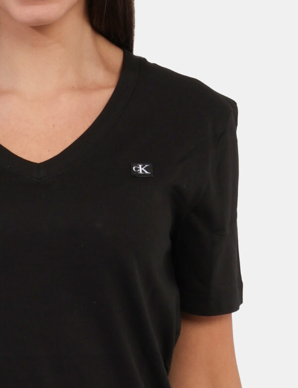 T-shirt Calvin Klein Nero - T-shirt con scollo a V in total nero con logo brand ad altezza cuore. La vestibilità è morbida e
