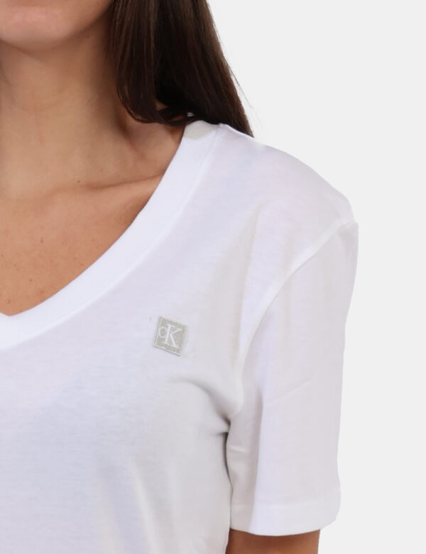 T-shirt Calvin Klein Bianco - T-shirt con scollo a V in total bianco con logo brand ad altezza cuore. La vestibilità è morbi