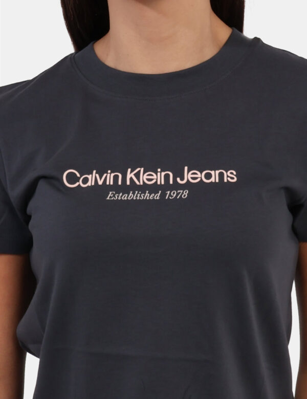 T-shirt Calvin Klein Grigio - T-shirt classica, corta, su base grigio scuro con stampa logo brand in tinta rosa chiaro. La v