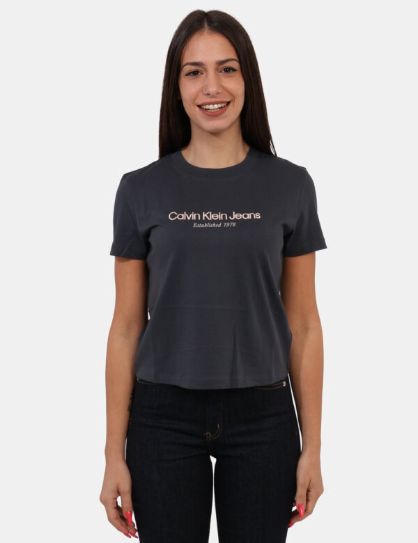 T-shirt Calvin Klein Grigio - T-shirt classica, corta, su base grigio scuro con stampa logo brand in tinta rosa chiaro. La v
