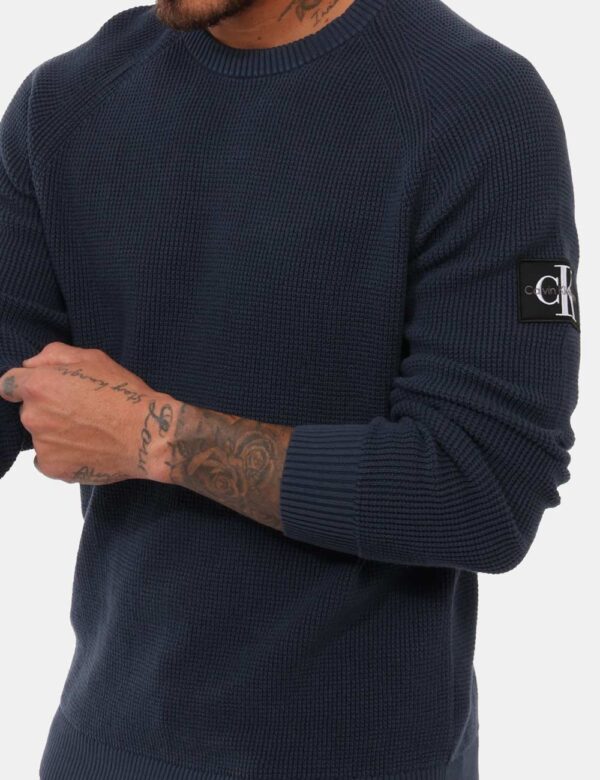 Maglia Calvin Klein Blu - Maglia uomo in total blu/grigiastro con trama lavorata e girocollo classico. La vestibilità è mor
