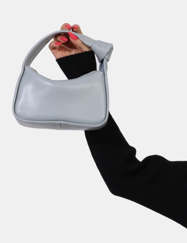 Borsa Calvin Klein Grigio - Borsa simil pochette di piccole dimensioni in total grigio chiaro. Presente unico scompartimento